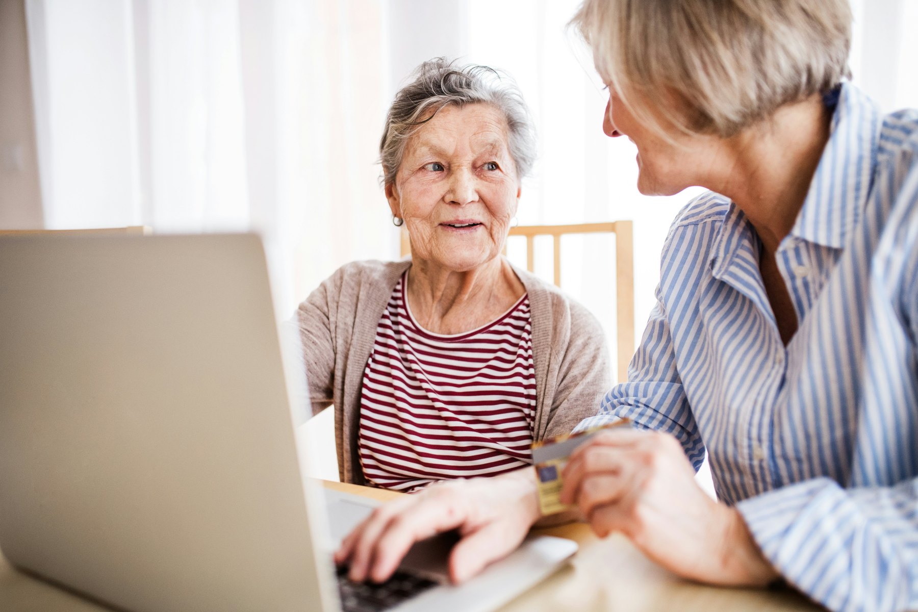 An adviser working through a plan on a laptop with an older client