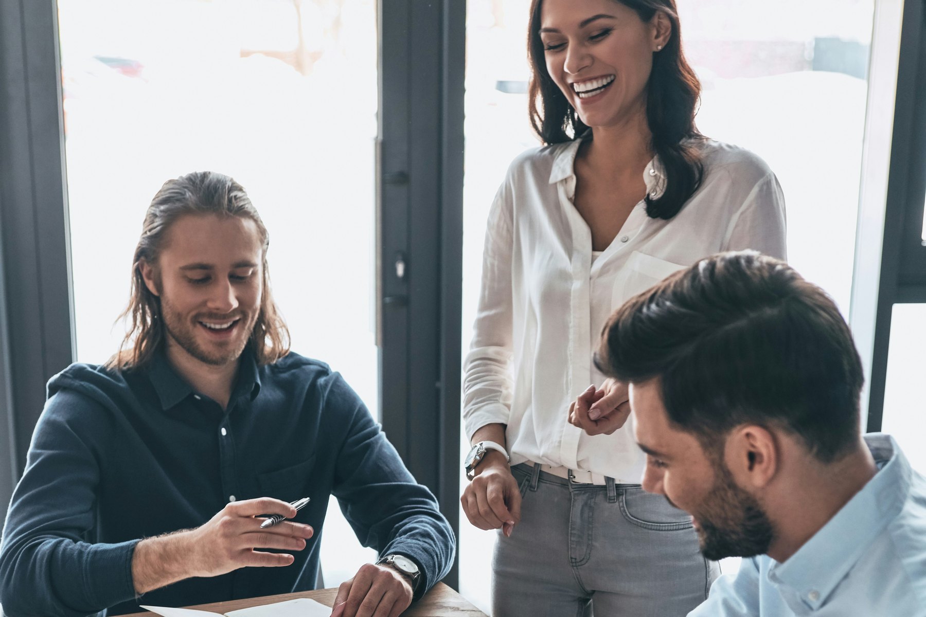 Three colleagues in an advice practice working through client files together at a meeting table