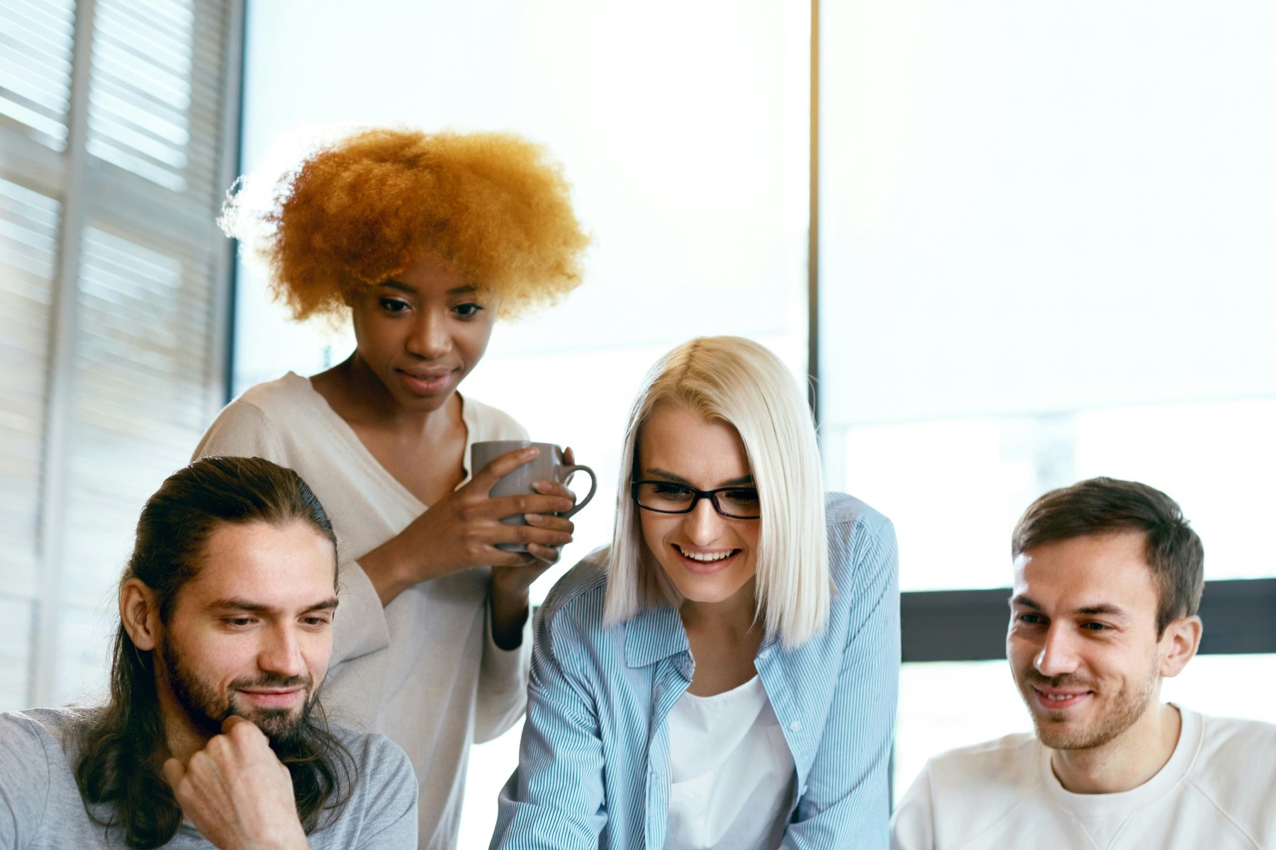 A small group of people working through financial questions together around a laptop