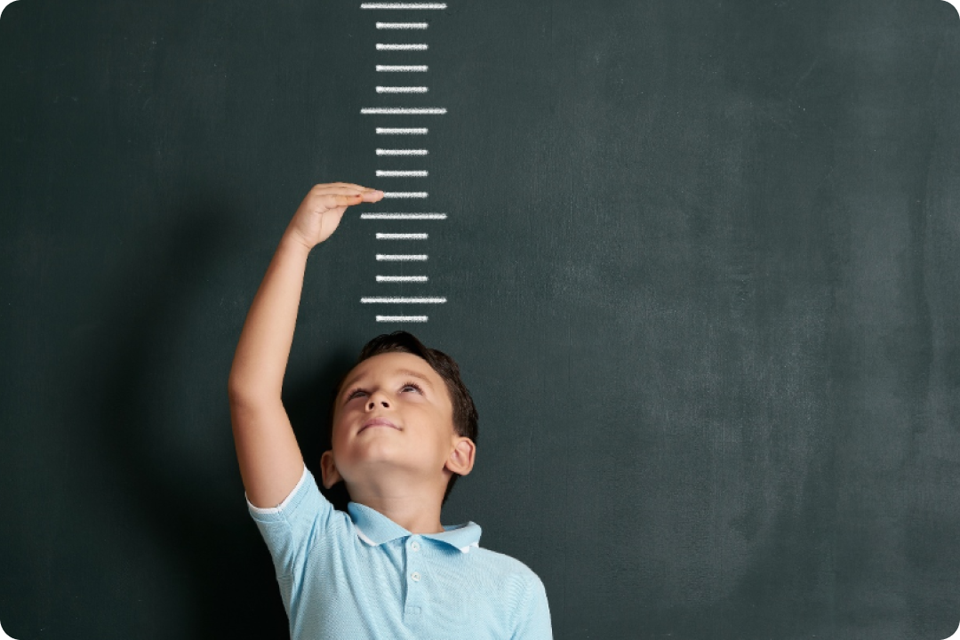 Little boy measuring height against wall