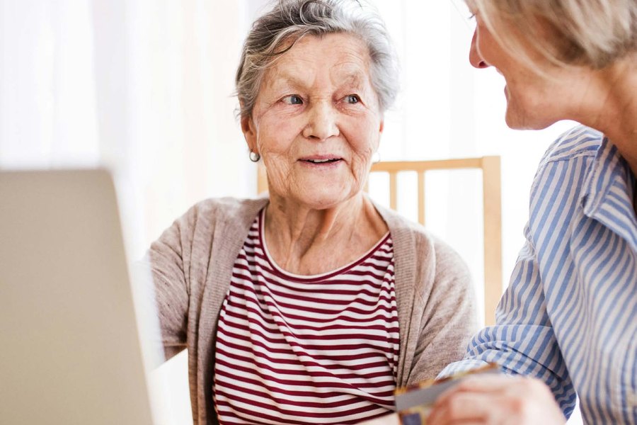 An older woman going through documents with a younger woman beside her