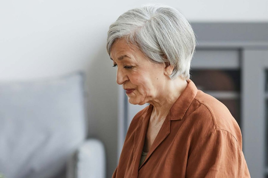 An older woman working on a laptop at home