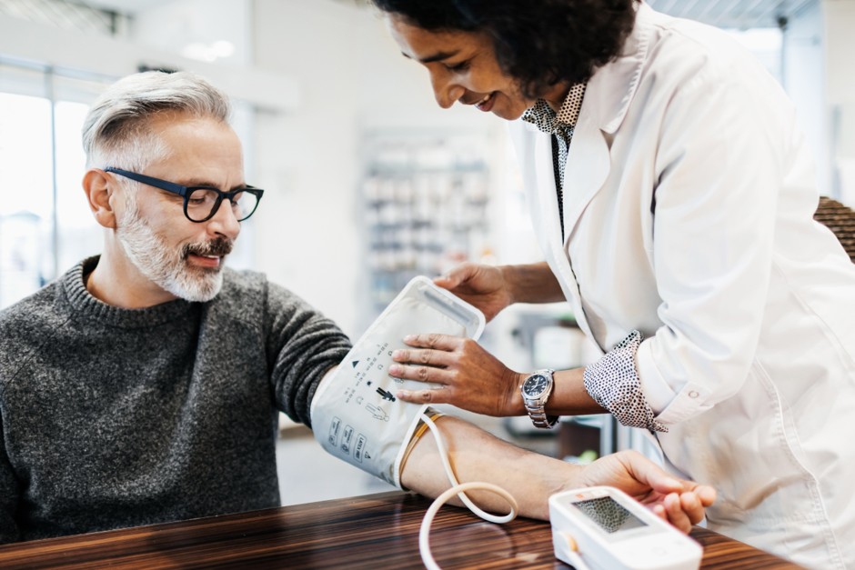 A clinician checking a patient's blood pressure during a consultation
