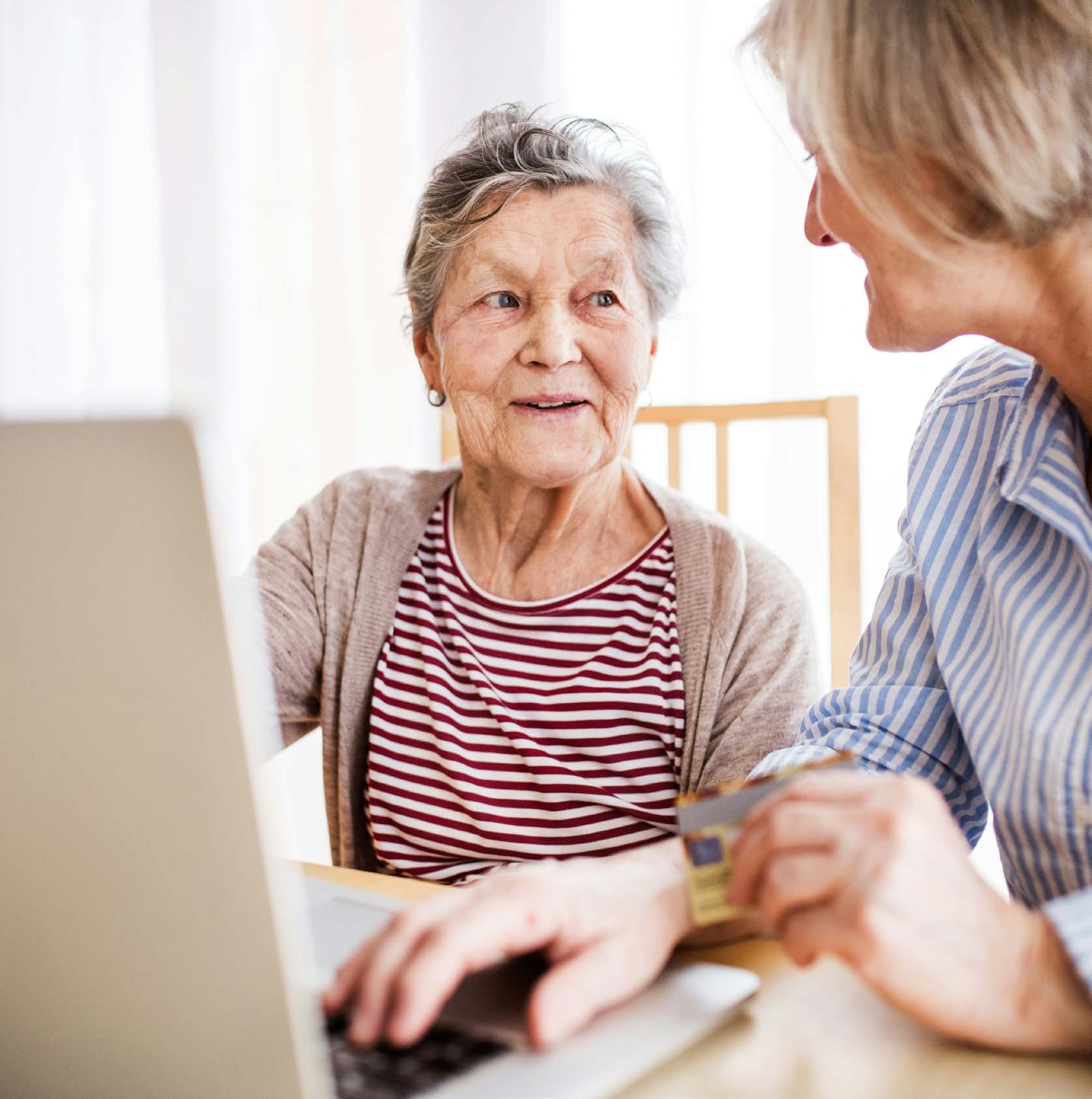 A licensed adviser going through a client's financial plan with her at a laptop