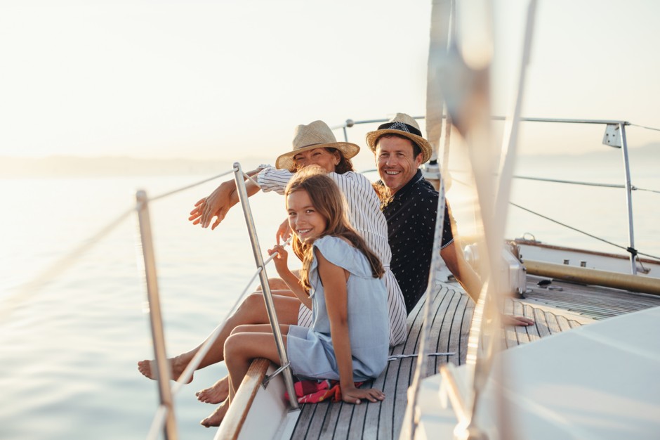 A family sitting on the deck of a yacht at sunset on Port Phillip