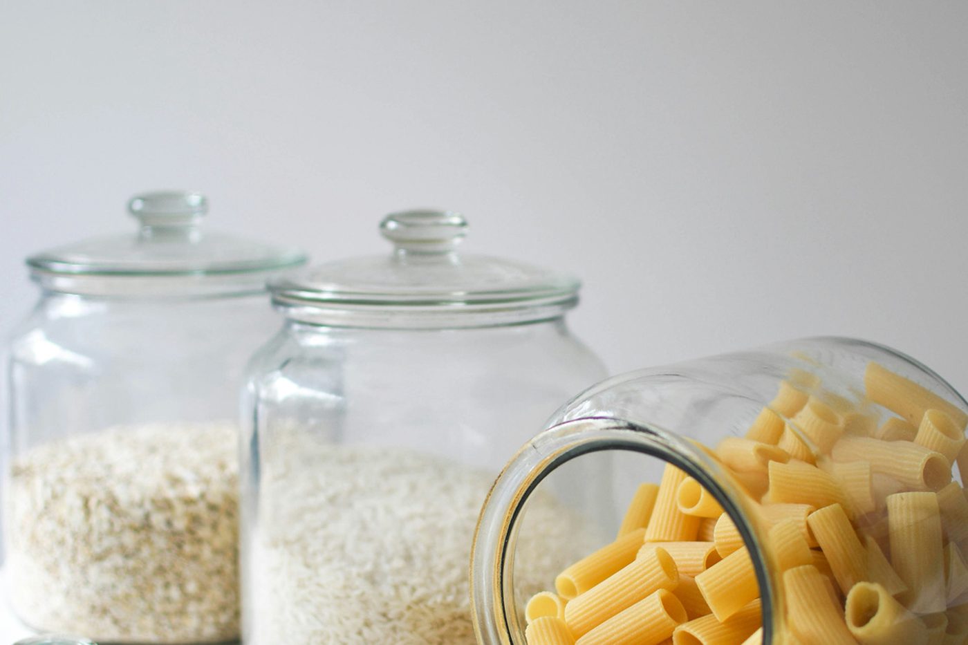 Large glass jars of rice and pasta on a shelf
