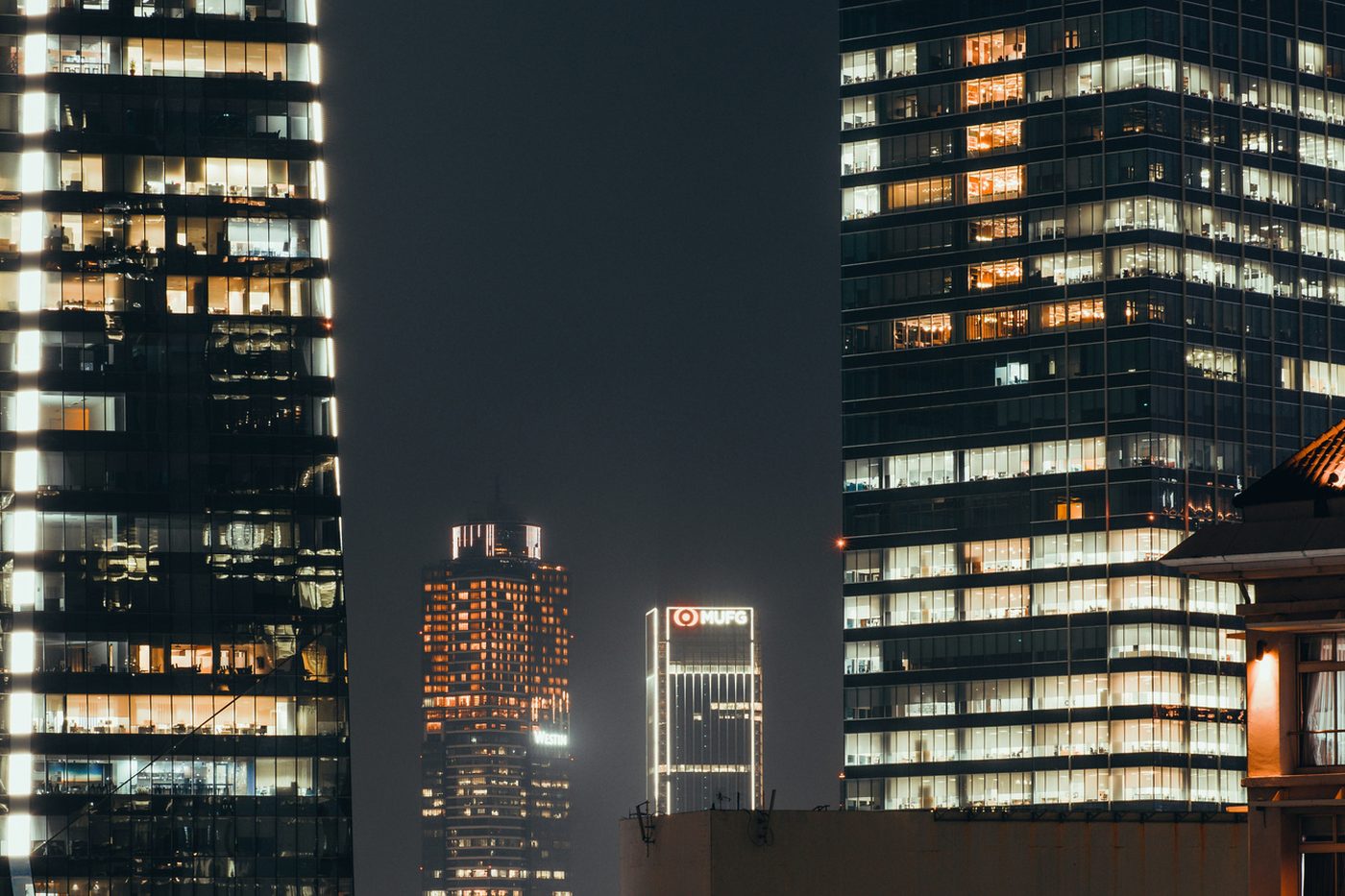 Office towers lit up against a night sky